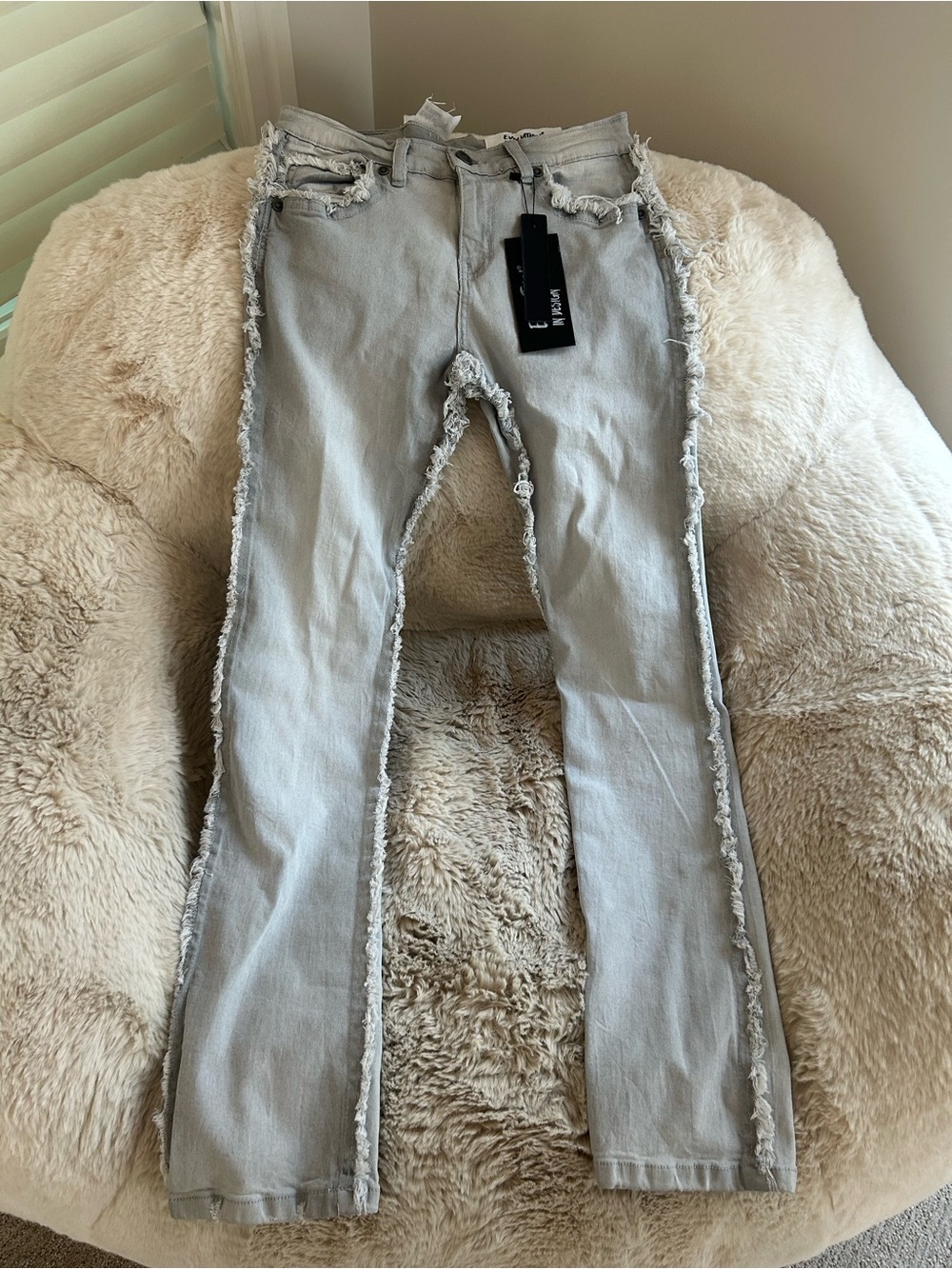 NWT Evolution in Design jeans feature distressed detailing and raw-edge cutouts.